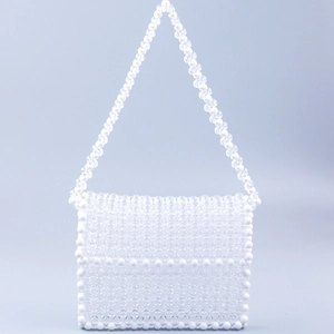 Close-up of handmade white and transparent acrylic beaded weave on a small square bag
