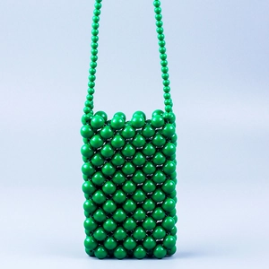 Vue détaillée du tissage artisanal en perles acryliques vertes du sac bandoulière