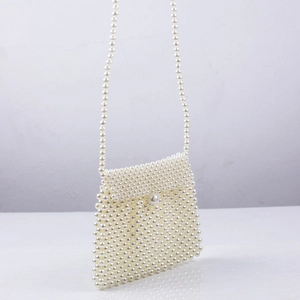 Handmade cream pearl crossbody dumpling bag with fold-over flap and long bead strap
