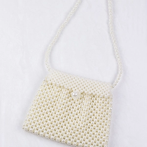 Detailed view of handmade faux pearl beaded dumpling bag with crossbody strap
