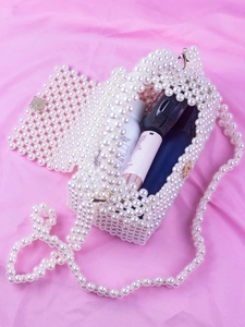 Vue détaillée de l'intérieur du sac en perles blanches avec cosmétiques et rangement