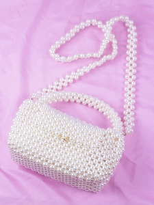 Détail d'un sac à main en perles blanches tressées avec un fermoir doré métallique