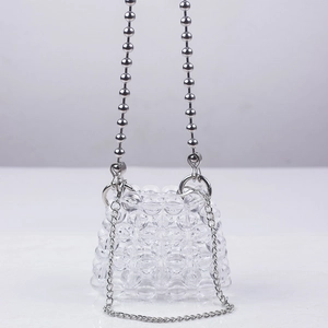 Detail of hand-woven mini beaded bag featuring dual silver chains and clear beads
