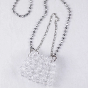 Detailed macro view of clear acrylic beaded mini bag with dual silver metal chains