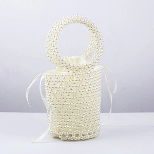 Close-up of handmade pearl bucket bag featuring satin drawstring lining and ribbon detail