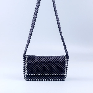 Close-up of handmade messenger bag with purple matte beads and silver metallic accents