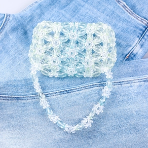 Sac à main artisanal en perles acryliques vertes à fleurs avec bandoulière sur denim
