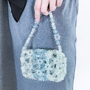 Gros plan d'un sac à main en perles fait main avec motifs floraux bleu et vert