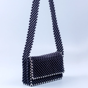 Close-up of handmade crossbody bag with matte black and silver accent beads