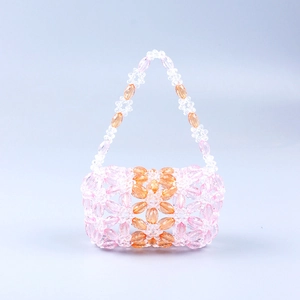 Détail de perles en acrylique rose et ambre sur un sac à main tissé à fleurs fait main