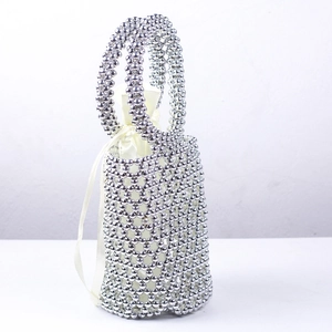 Detailed shot of silver beaded bucket bag with cream satin drawstring lining