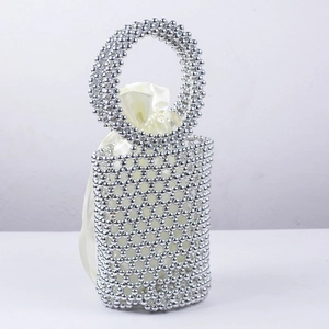 Close-up of silver beaded bucket bag featuring round handle and satin drawstring liner