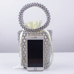 Detail of silver beaded bucket bag featuring a satin drawstring pouch and round handle