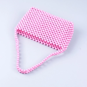 Detailed view of pink faceted acrylic beads and handmade woven structure of the bag