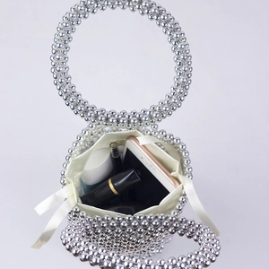 Detailed top view of handmade beaded bucket bag with silver pearls and fabric inner pouch