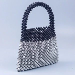 Détail du sac trapèze fait main avec perles noires mates et finition argentée miroir
