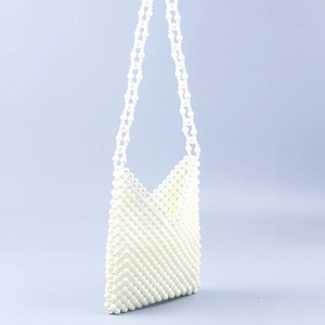 Macro shot of handcrafted cream white pearl weave and texture on an elegant crossbody bag
