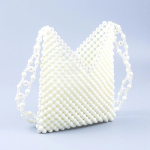 Detailed view of handmade ivory acrylic pearl beaded handbag with triangular woven pattern