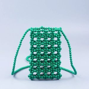 Detailed view of the handcrafted green beaded lattice texture on a compact phone crossbody bag