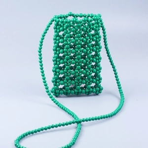Detail of emerald green beaded phone bag with handmade hollow weave and strap