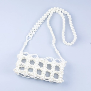 Detail of handmade faux pearl woven mini crossbody bag with hollow grid pattern