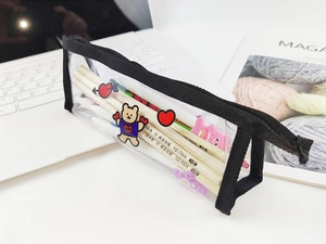 Gros plan d'une trousse transparente en PVC avec motifs ours et fournitures scolaires
