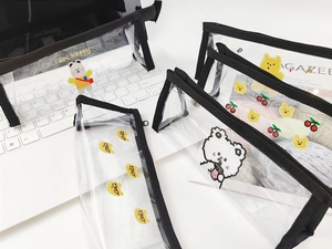 Détail de trousses en PVC transparent avec motifs d'ours et fermeture éclair noire