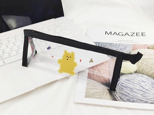 Détail d'une trousse transparente en PVC avec motif ours jaune et fermeture éclair noire