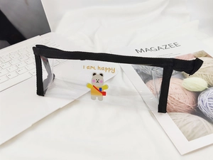 Détail de la trousse transparente en PVC avec motif d'ours et bordure en tissu noir