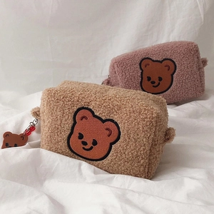 Detail of cute teddy bear embroidery on soft sherpa fleece cosmetic storage bags