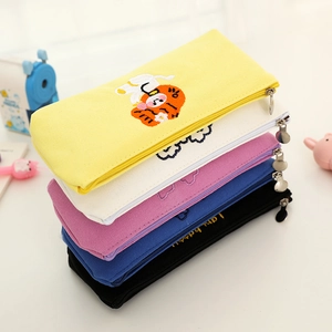 Detail of colorful canvas pencil cases with cute cartoon bear embroidery and metal zippers