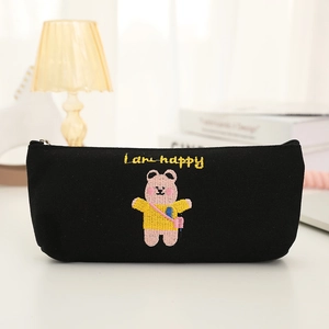Close-up of black canvas pencil case featuring embroidered pink bear and happy text