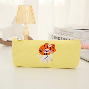 Close-up of cute embroidered tiger on yellow canvas pencil case with a smooth zipper