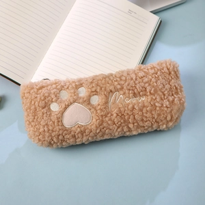 Detailed close-up of khaki plush pencil case with cute cat paw embroidery and Meow text