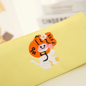 Close-up of cute cartoon tiger embroidery on a cream canvas pencil case detail