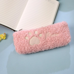 Detailed view of pink lamb wool pencil case featuring cat paw embroidery and Meow text