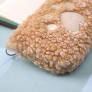 Close-up of brown plush cat paw pencil case with soft faux fur texture and metal ring
