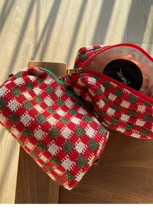 Detail van rood en groen gebreide make-uptas met textuurweefsel en gouden ritssluiting