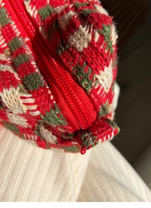 Macro-opname van rood en groen grof gebreide geruite stof met een nylon ritssluiting