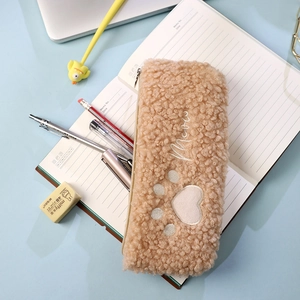 Close-up of curly plush pencil case with cat paw embroidery and metal zipper detail