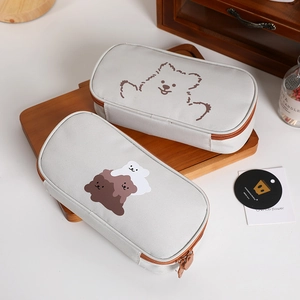 Detail of grey canvas pencil cases with cute bear illustrations and metal zippers