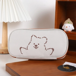 Close-up of canvas stationery pouch featuring a cute dog illustration and zipper detail