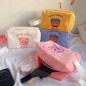 Close-up of colorful corduroy makeup bags with cute bear embroidery and travel text