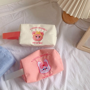 Detail of embroidered corduroy makeup bag with cute bear and rabbit motifs