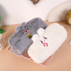 Dettaglio di astucci in morbido peluche in un cesto rosa con ricamo carino e dolce