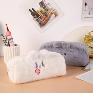 Dettaglio degli astucci per orsetti in peluche bianchi e grigi con musi ricamati