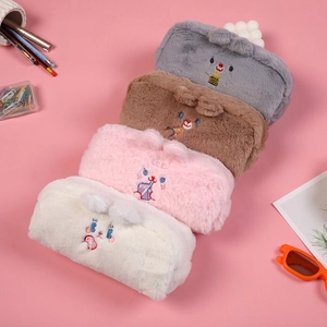 Dettaglio degli astucci in peluche nei colori grigio, marrone, rosa e avorio delicato