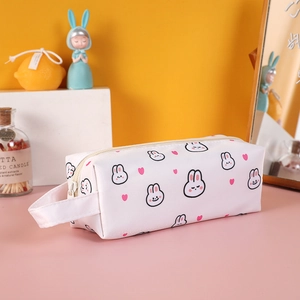 Close-up of a white leather pencil case with rabbit patterns and a side carry handle