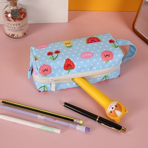 Light blue high-capacity pencil case with fruit prints and portable handle on pink desk