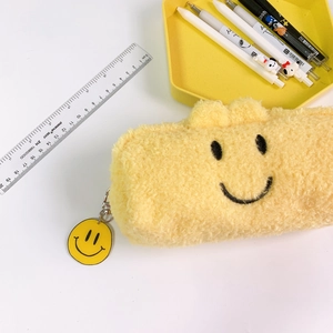 Cute yellow plush pencil case with smiling face embroidery and matching round charm pendant